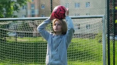 Sahada futbol topuna liderlik etmeyi öğrenen küçük kız.