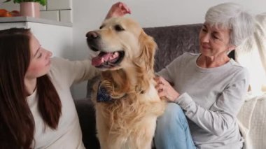 Yaşlı kadın ve torunu tatlı bir köpekle eğleniyorlar.