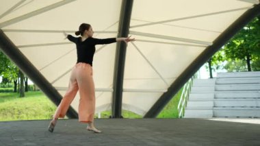 Balo dansı eğitiminin bir parçası olarak açık havada dans eden genç kız.