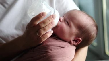 Anne yenidoğan bebek formülünü bir şişeden besliyor Bebek süt formülünü tüketirken
