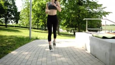 Spor yapan ve parkta koşan formda bir kız.