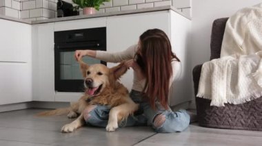 Genç kız tatlı bir köpeğin kulaklarıyla usulca oynuyor.