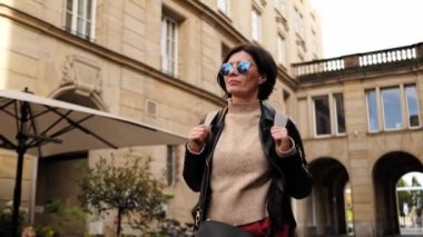 Güneş Gözlüklü Çekici Kadın Sırt çantasıyla Şehirde Yürüyor, Etrafa Bakınan Kadın Turist