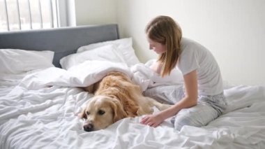 Neşeli genç kız, altın av köpeğiyle eğleniyor, battaniyeye sarıp...