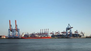 Hamburg, Almanya - 07 Temmuz 2023: Endüstriyel limandan denize açılan konteynırlarla birlikte nakliye gemisinin zaman aşımı