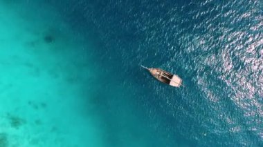 Zanzibar 'daki balıkçı köyünün yakınındaki okyanusun şeffaf sularında ıssız bir teknede insansız hava aracından inanılmaz bir manzara.