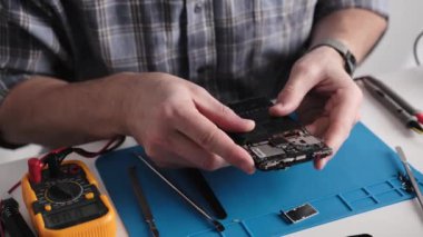 Tamir atölyesinde Bozuk Telefonu Denetleyen Servis Teknisyeni