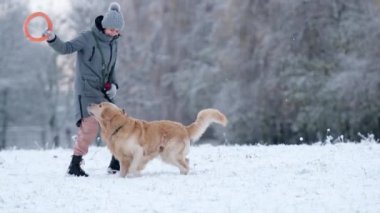 Kışın dışarıda Golden Retriever Dog 'la oynayan kız.