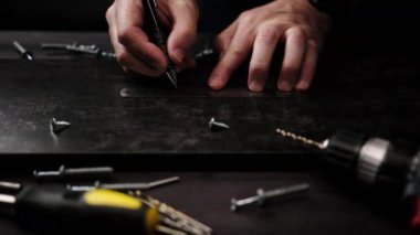 Marangoz ev rafları yapmak için siyah parçacık plank işaretliyor