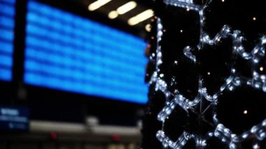 Büyük Aydınlanmış Geliş ve Gidiş Kurulu tren istasyonunda bir Noel ağacının yanında duruyor.