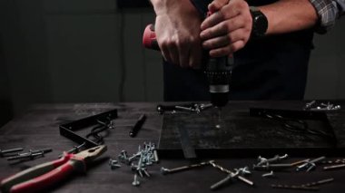 Marangoz, mutfak rafları yapmak için atölyeye ahşap bir tahta deliyor.