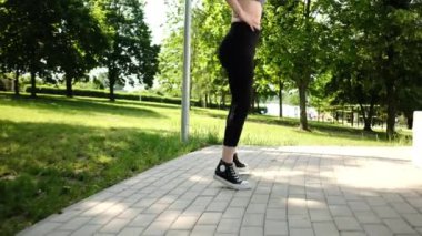 Formda kız spor yapıyor ve parkta koşuyor.