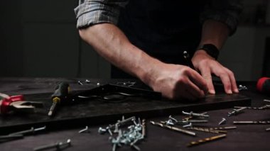 Marangoz, bir ev için dekoratif bir raf yapmak için atölyedeki parçacık planlarını işaretliyor