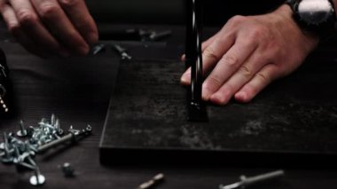 Marangoz ev rafları yapmak için siyah parçacık tahtasını işaretliyor