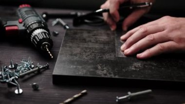 Marangoz ev rafları yapmak için siyah parçacık plank işaretliyor