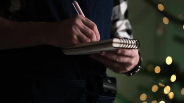 Garson bir not defterine Noel siparişi yazıyor restorandaki bir müşteriden sipariş alıyor.