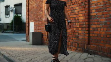 Çekici bir genç kadın Avrupa 'nın tarihi bölgesinde yürüyor ve siyah elbiseli şık bir kız eski sokakların orada dolaşıyor.