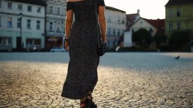 Orta Meydan yakınlarındaki bir Avrupa şehrinin tarihi bölümünde yürüyen genç bir kadın kaldırım taşlarıyla süslenmişti.