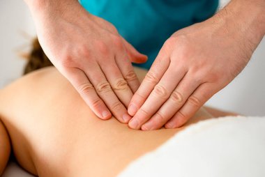 Yetenekli masaj terapistinin elleri spa salonundaki kıza sağlık masajı yapıyor.