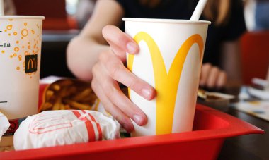 Poznan, Polonya - 28 Nisan 2024: McDonald 's Fast Food' ta Küçük Kız Soğuk Soda İçiyor