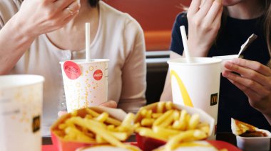 Poznan, Polonya - 28 Nisan 2024: Anne ve Küçük Kızı McDonald 's Fast Food Lokantasında Kızarmış Patates ve Sodanın keyfini çıkarıyorlar