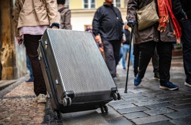 Cobblestone Caddesi 'nde, kalabalığın ortasında büyük bir valizle turist.