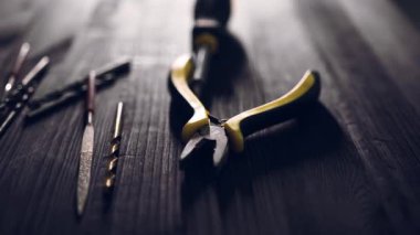 Masada, bir ev işçisinin aletleri matkap uçları, tornavida parçaları ve pense içerir.