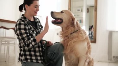 Yürüyüşe çıkmadan önce köpeğe pençe atmasını söyleyen bir kız.