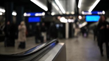 İstasyonda yolcu trenleri ve tren bekleyen insanlarla dolu bir platform.