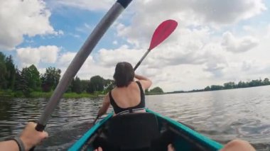 Aile, gölde mutlu bir hafta sonu kanosunun tadını çıkardı senkronize kürekler eşliğinde kürek çektiler.