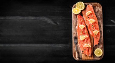 Limonlu alabalık fileto balığı. Kopya alanı olan bir kesme tahtasında pişirmeye hazır.