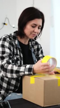 Sevkiyat için karton kutu paketleyip sarı bant ve dikey video ile mühürlemek