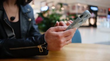 İnternet 'te Sörf Yapan Genç Kadın Ticaret Merkezi' nde Akıllı Telefon Kullanıyor