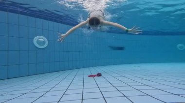 Yüzme havuzunda gözlük takan ve Aquapark suyunda oynayan sevimli küçük kız.