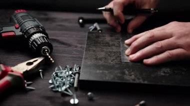 Marangoz ev rafları yapmak için siyah parçacık plank işaretliyor