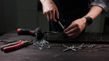 Marangoz bir ev için el yapımı raflar yapıyor ve mobilyalar için metal destekleri vidalıyor