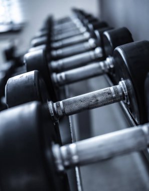 Spor salonundaki rafta duran dambılların yakın çekimi.