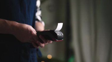 Garson, bir restoranda Pos Terminali ile bir makbuz basıyor, kablosuz ödeme konsepti