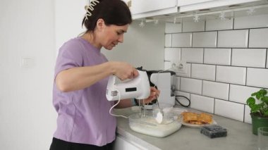 Mutfakta Belçika Waffle 'ları için krema hazırlayan bir kadın.