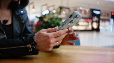 Ticaret Merkezi 'nde akıllı telefon kullanan genç bir kadın internette indirim ve satış arıyor.
