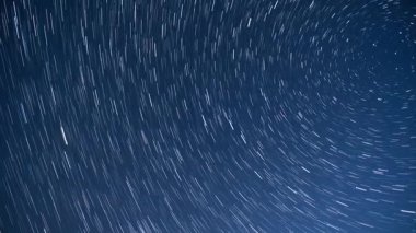 Karanlık bir gecede hareket eden yıldız izleri Bir zaman atlamasında