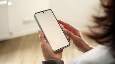 Metnin ve tasarımın için Beyaz Ekran Boşluğu Olan Akıllı Telefonu Tutan Kadın