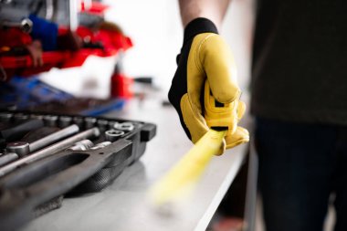 Otomatik Tamirci Hizmetteyken Elde Ölçüm Bantını Tutuyor