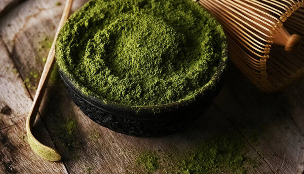 Маття зеленый чай порошок в миске с венчиком для взбивания и чай бамбуковой ложкой