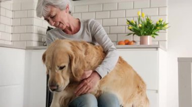 Neşeli yaşlı bayan, altın dişli köpeğiyle eğleniyor.