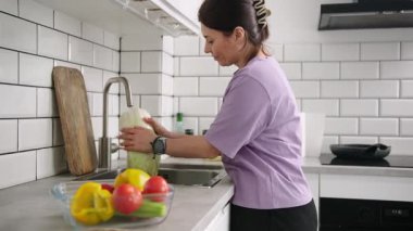 Mutfakta salata hazırlamak için sebze ve lahana yıkayan kız.