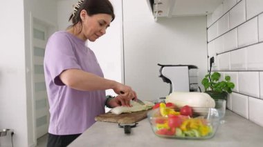 Mutfakta sebze salatası için kesme tahtasında Çin lahanası dilimleyen kız.