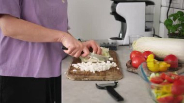 Mutfakta sebze salatası için kesme tahtasında Çin lahanası dilimleyen kız.