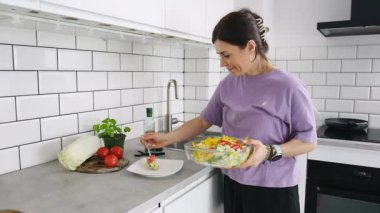 Öğle yemeği için sebze salatası yapan kadın tabakta hazırlıyor.