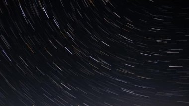 Karanlık bir gecede yıldız izleri zaman içinde kaybolur.